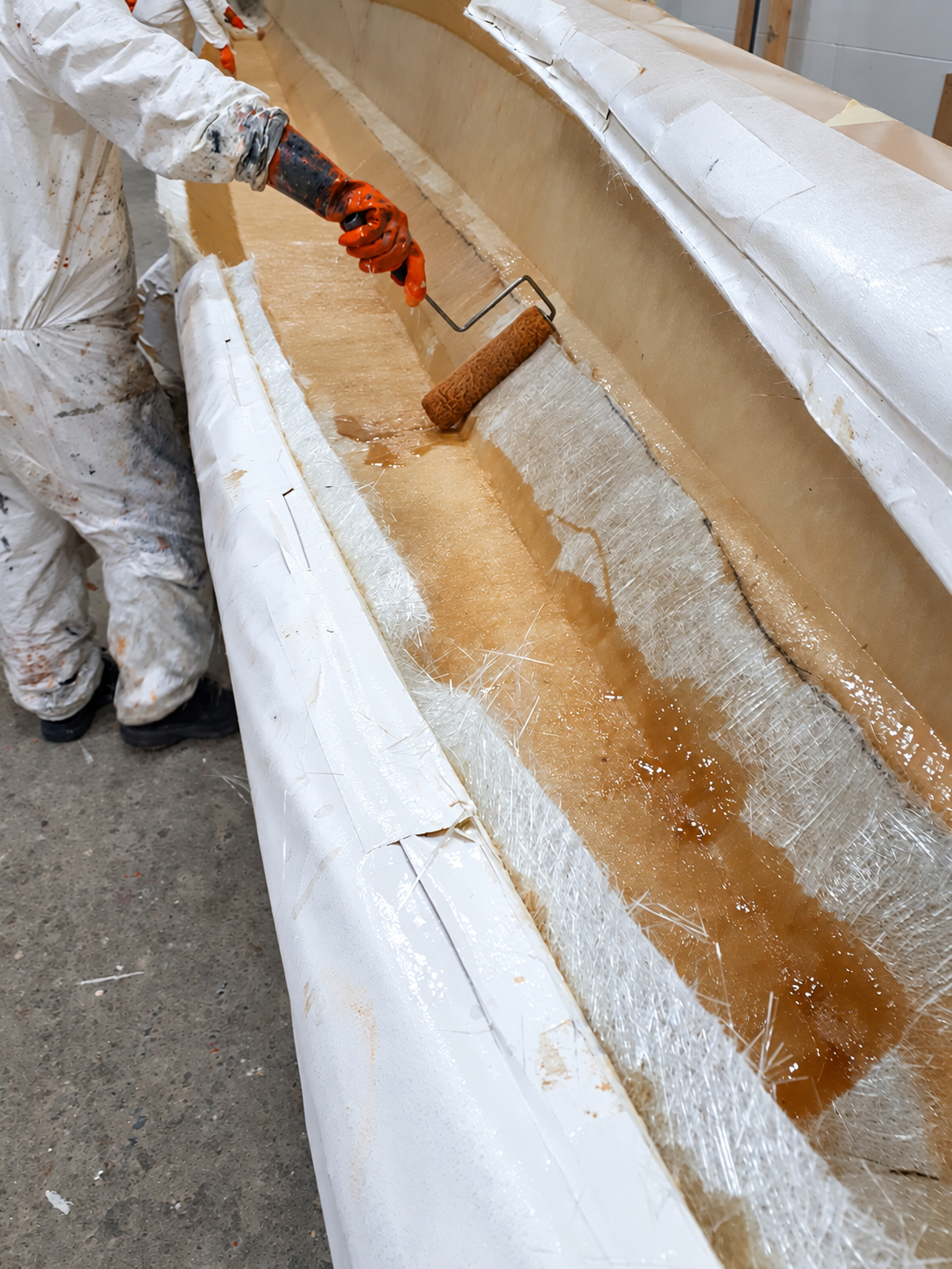 Technician hand-laying fibreglass into a mold